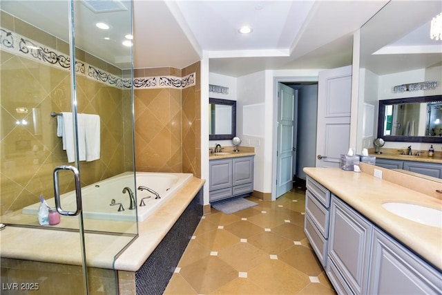 bathroom featuring vanity, tile patterned floors, and tiled tub