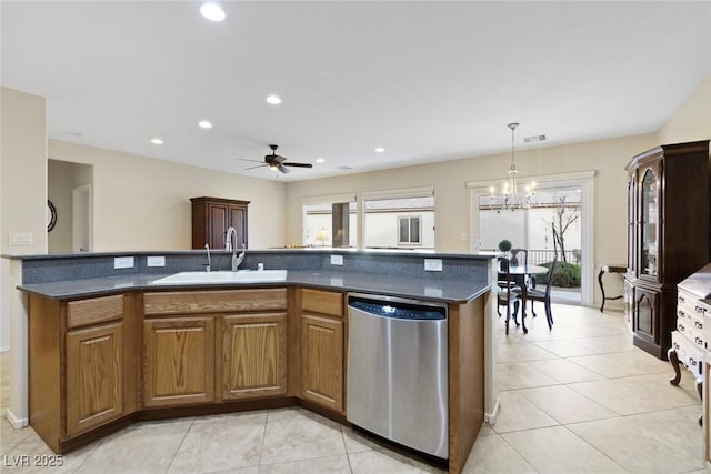 kitchen with dishwasher, ceiling fan with notable chandelier, an island with sink, and sink