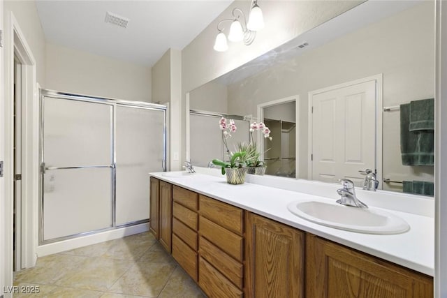 bathroom with double vanity, visible vents, a shower stall, and a sink