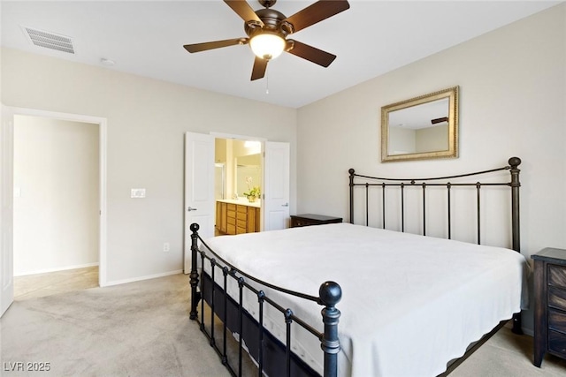 bedroom featuring light carpet, baseboards, visible vents, a ceiling fan, and ensuite bath