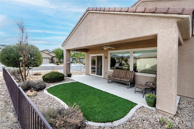 rear view of property featuring a patio, fence, stucco siding, ceiling fan, and a tile roof