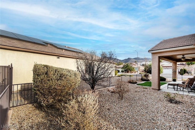 view of yard featuring a mountain view, fence private yard, a ceiling fan, and a patio area