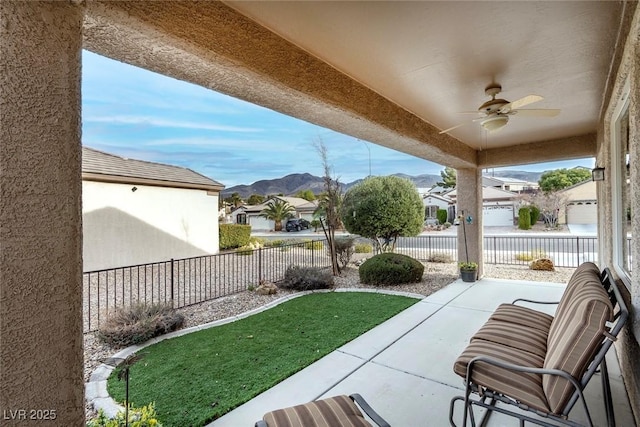 view of yard featuring a mountain view, a patio area, a ceiling fan, and fence