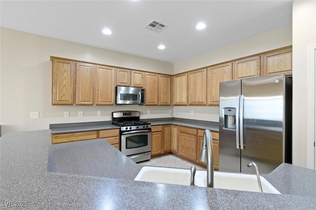 kitchen with visible vents, recessed lighting, a sink, appliances with stainless steel finishes, and dark countertops