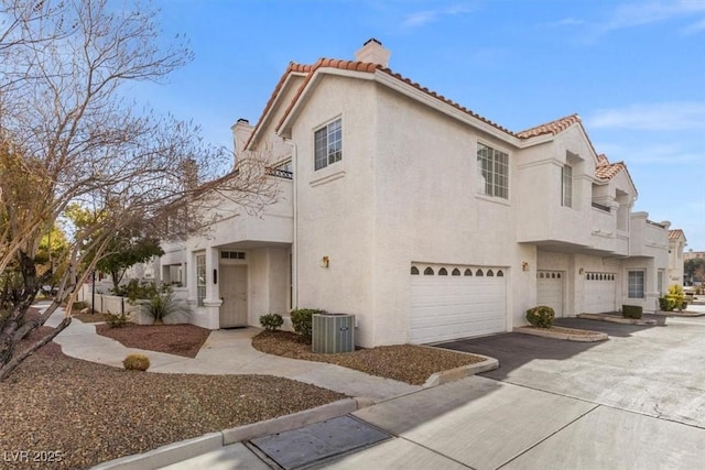 view of front of property featuring a garage and cooling unit