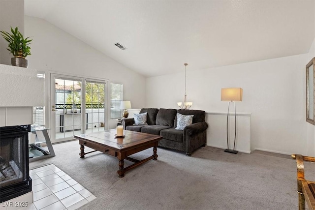 carpeted living room featuring a notable chandelier, high vaulted ceiling, and a multi sided fireplace