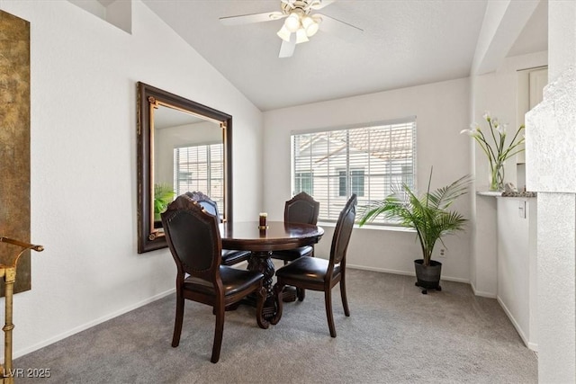 carpeted dining room with vaulted ceiling, ceiling fan, and plenty of natural light