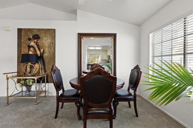 carpeted dining room featuring vaulted ceiling