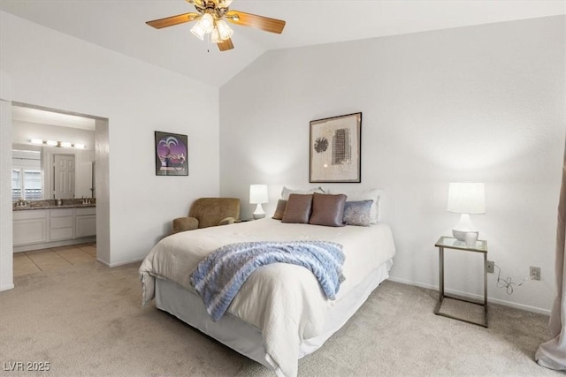 bedroom with ceiling fan, light colored carpet, lofted ceiling, and connected bathroom