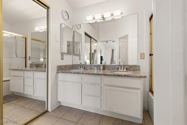 bathroom featuring tile patterned flooring, vanity, and bath / shower combo with glass door