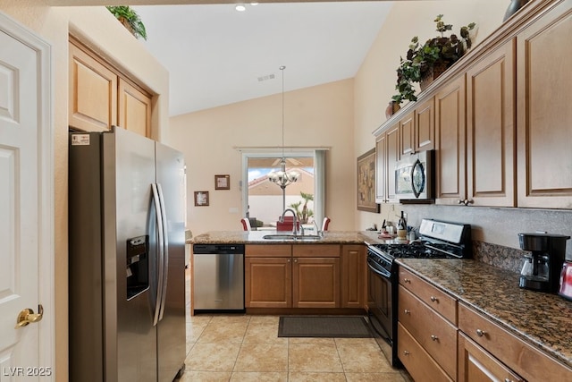 kitchen featuring pendant lighting, lofted ceiling, an inviting chandelier, sink, and appliances with stainless steel finishes