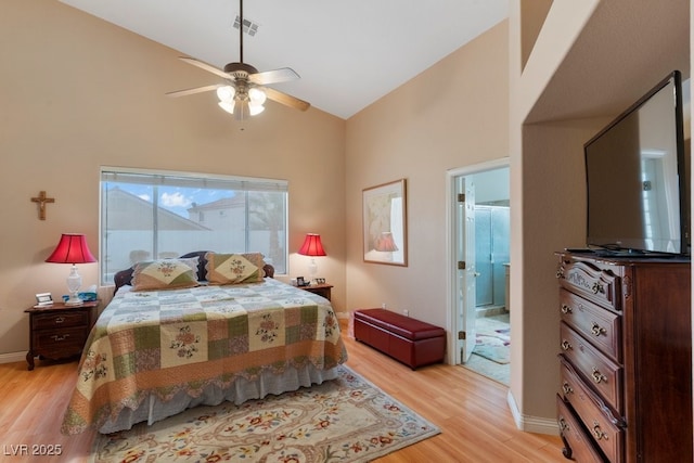 bedroom with ensuite bathroom, ceiling fan, light hardwood / wood-style floors, and high vaulted ceiling