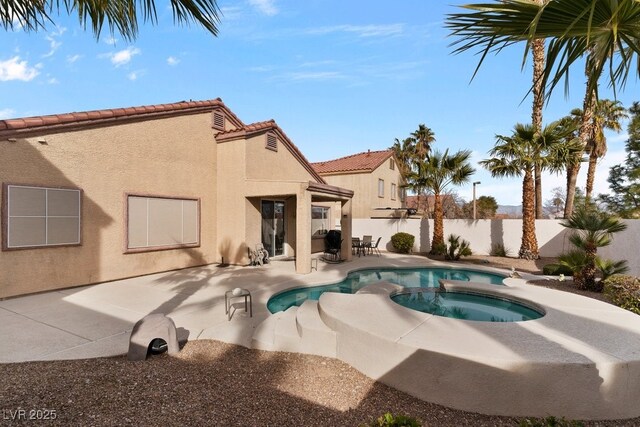 view of swimming pool featuring a patio area and an in ground hot tub