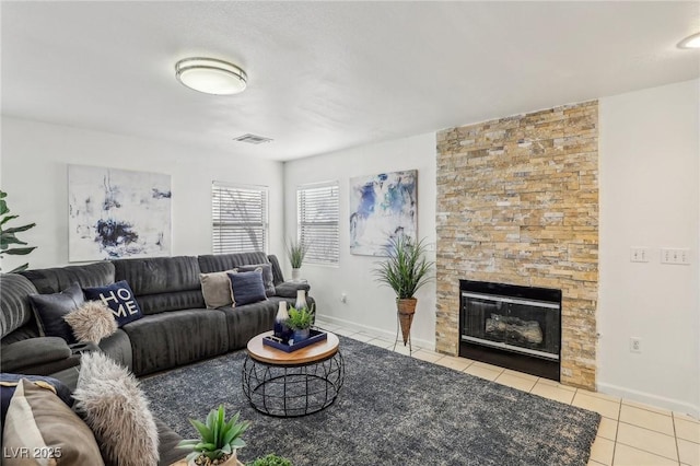 tiled living room with a stone fireplace