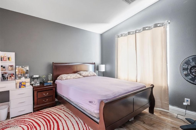 bedroom featuring hardwood / wood-style flooring and lofted ceiling