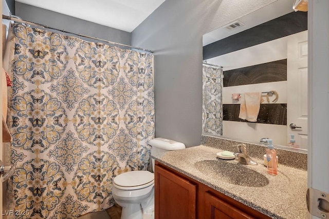 bathroom featuring vanity, a shower with shower curtain, and toilet