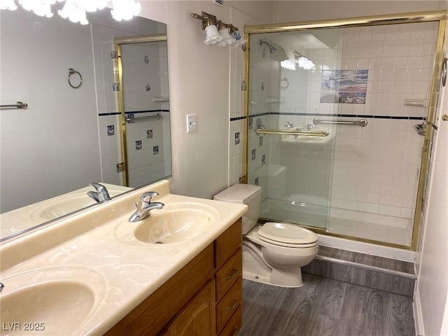 bathroom with hardwood / wood-style floors, vanity, toilet, and walk in shower