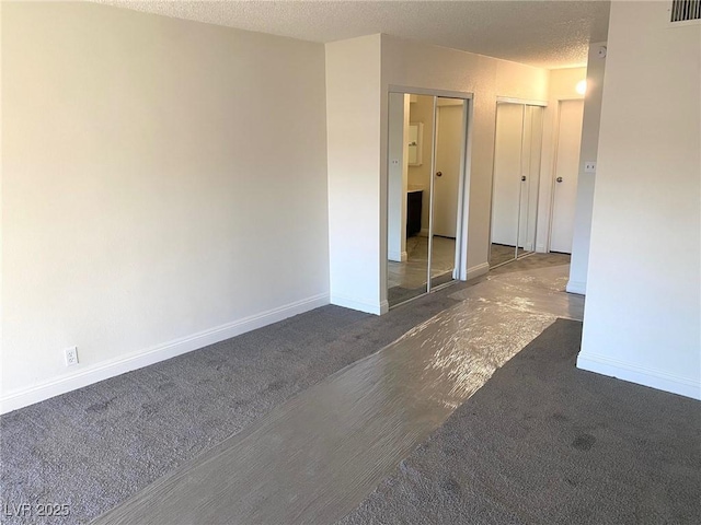 carpeted empty room featuring a textured ceiling