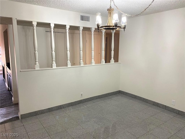 unfurnished room with a chandelier and a textured ceiling