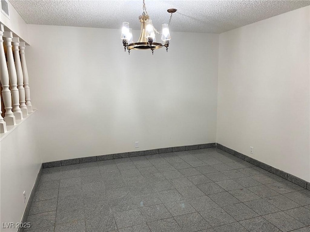 unfurnished room featuring a textured ceiling and a notable chandelier