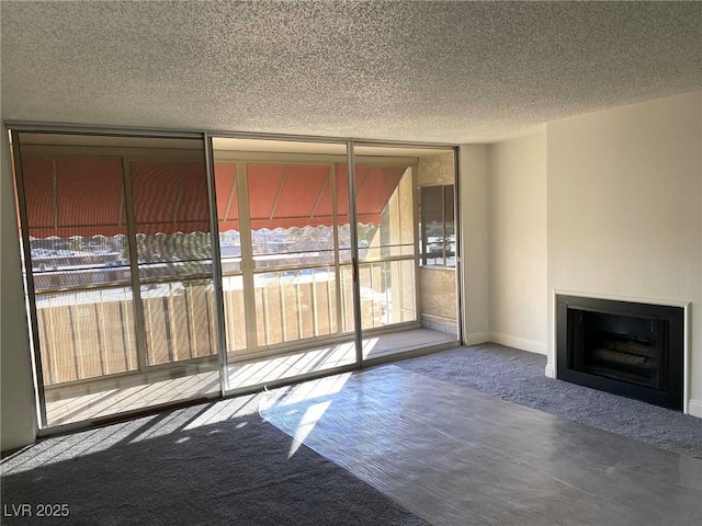 unfurnished living room featuring a fireplace, carpet, and a textured ceiling