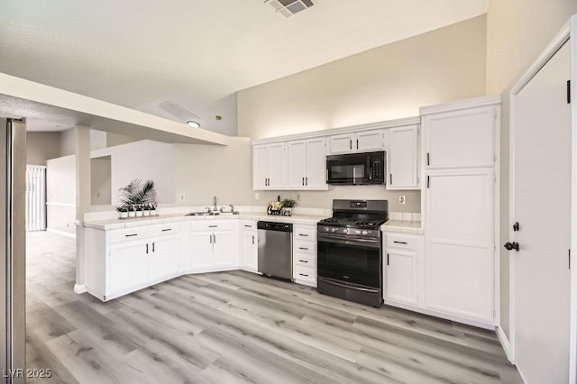 kitchen with sink, white cabinetry, high vaulted ceiling, light wood-type flooring, and stainless steel appliances