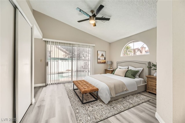 bedroom with lofted ceiling, a textured ceiling, access to outside, ceiling fan, and light hardwood / wood-style floors