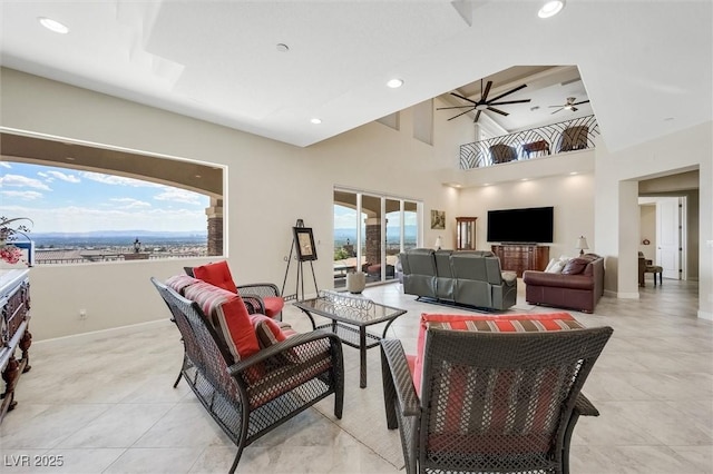 living room featuring a towering ceiling and ceiling fan