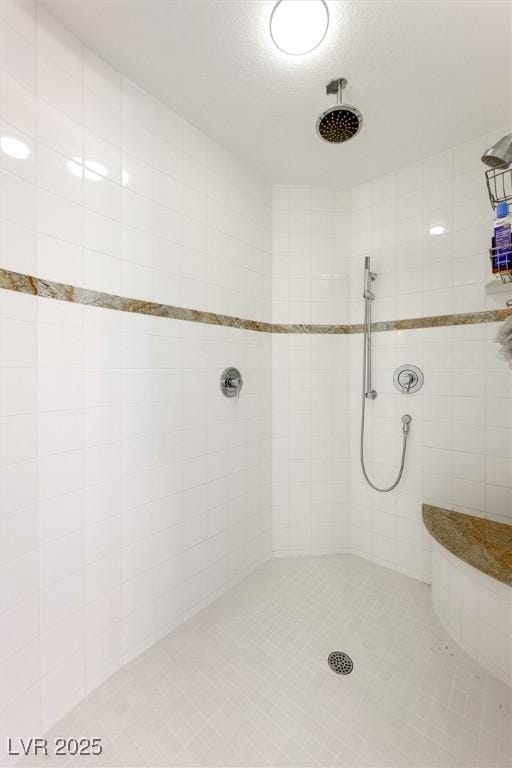 bathroom with tile patterned floors and a tile shower