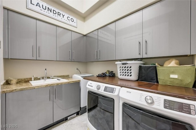 clothes washing area featuring cabinets, independent washer and dryer, and sink