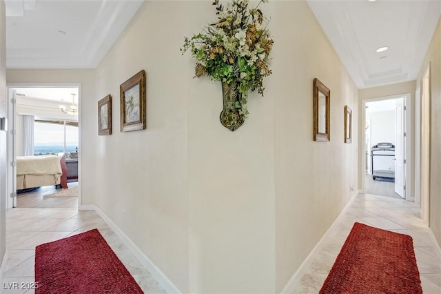 hall with light tile patterned floors and a notable chandelier