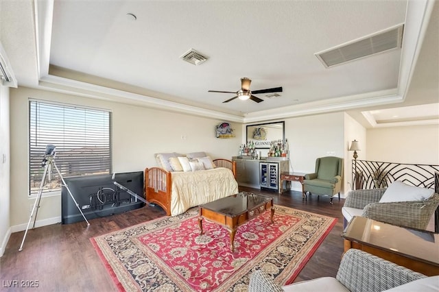 bedroom with dark hardwood / wood-style floors, wine cooler, ceiling fan, and a tray ceiling