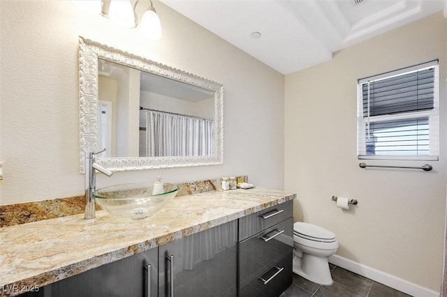 bathroom with tile patterned flooring, vanity, and toilet