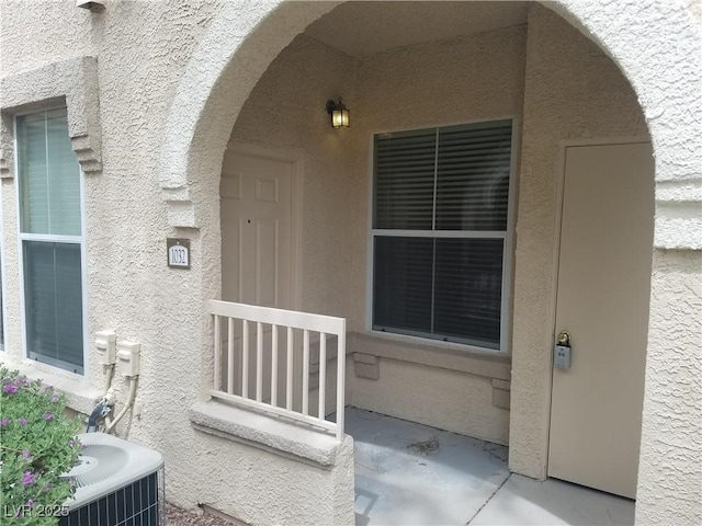 view of exterior entry with central air condition unit