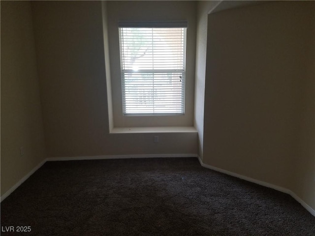 unfurnished room featuring dark colored carpet and a healthy amount of sunlight