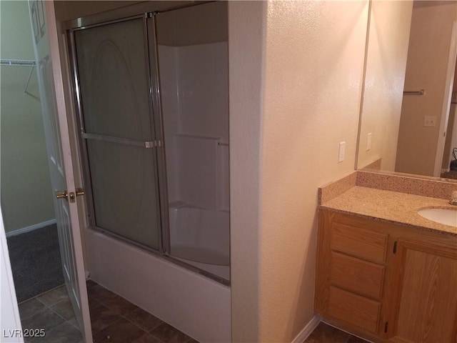 bathroom featuring tile patterned floors, vanity, and combined bath / shower with glass door