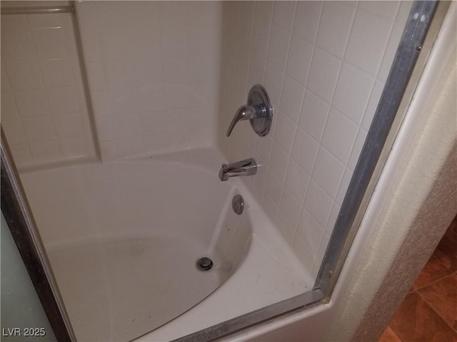 bathroom featuring tile patterned flooring and bathing tub / shower combination