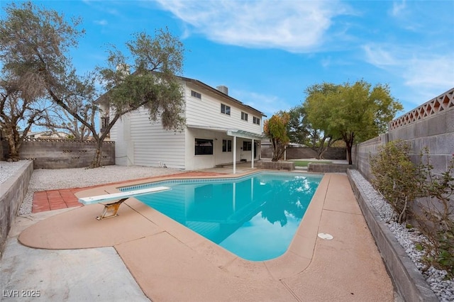 view of pool featuring a diving board and a patio area