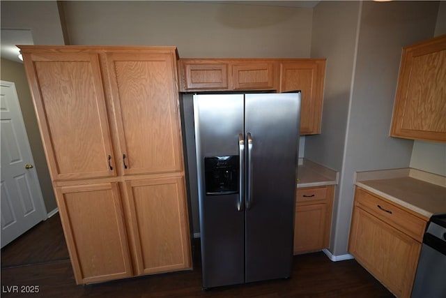 kitchen with light brown cabinetry, dark wood-type flooring, and stainless steel refrigerator with ice dispenser