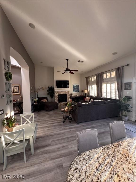 dining area with a fireplace, light hardwood / wood-style flooring, and ceiling fan