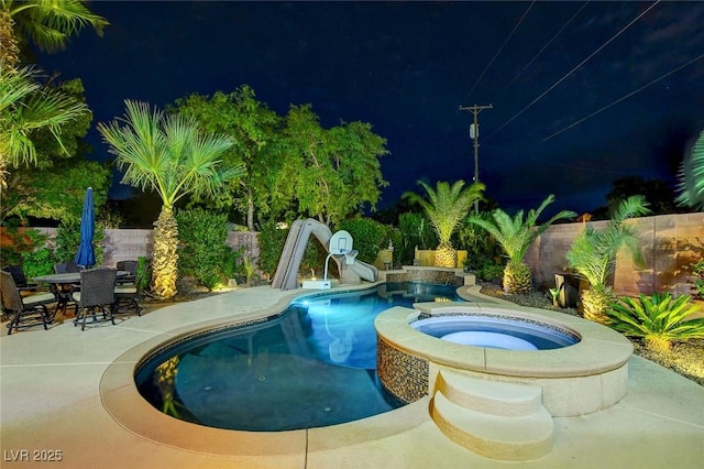 view of pool featuring an in ground hot tub, a patio area, and a water slide