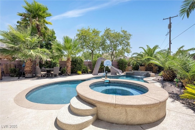 view of swimming pool featuring an in ground hot tub, a water slide, and a patio