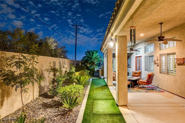 view of yard featuring ceiling fan and a patio area