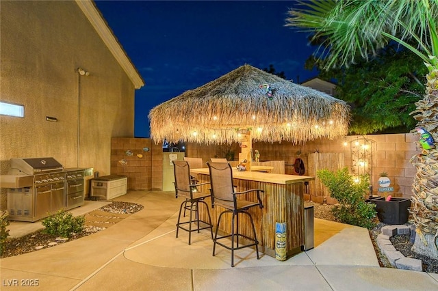 patio at twilight with exterior bar and grilling area