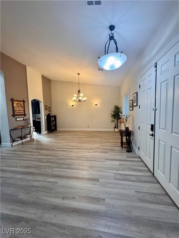 foyer entrance with a notable chandelier and light hardwood / wood-style floors