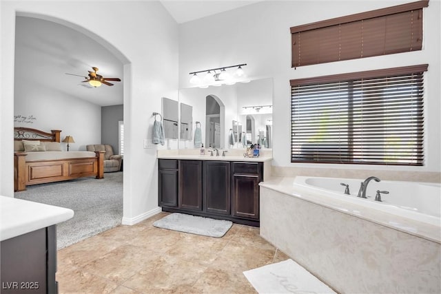 bathroom with ceiling fan, a tub, and vanity