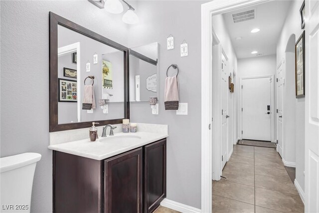 bathroom featuring toilet, vanity, and tile patterned flooring