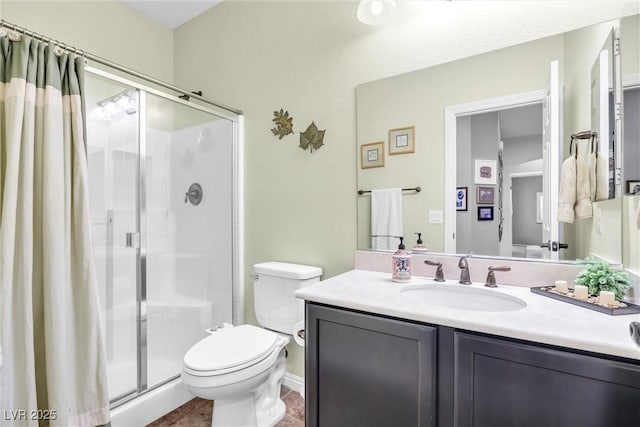 bathroom with toilet, vanity, and an enclosed shower