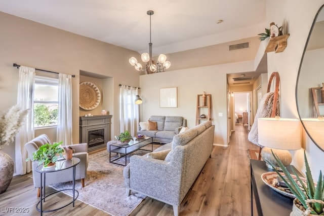 living room featuring light hardwood / wood-style floors and an inviting chandelier