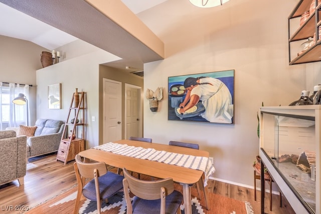 dining room with lofted ceiling and light hardwood / wood-style flooring